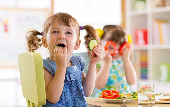 Kinder, die im Kindergarten oder zu Hause Gemüse essen